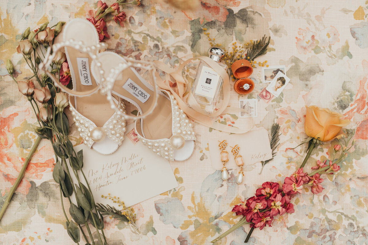 flay lay of jimmy choos, jo malone perfume, florals, grandmothers earrings and other loved pieces.