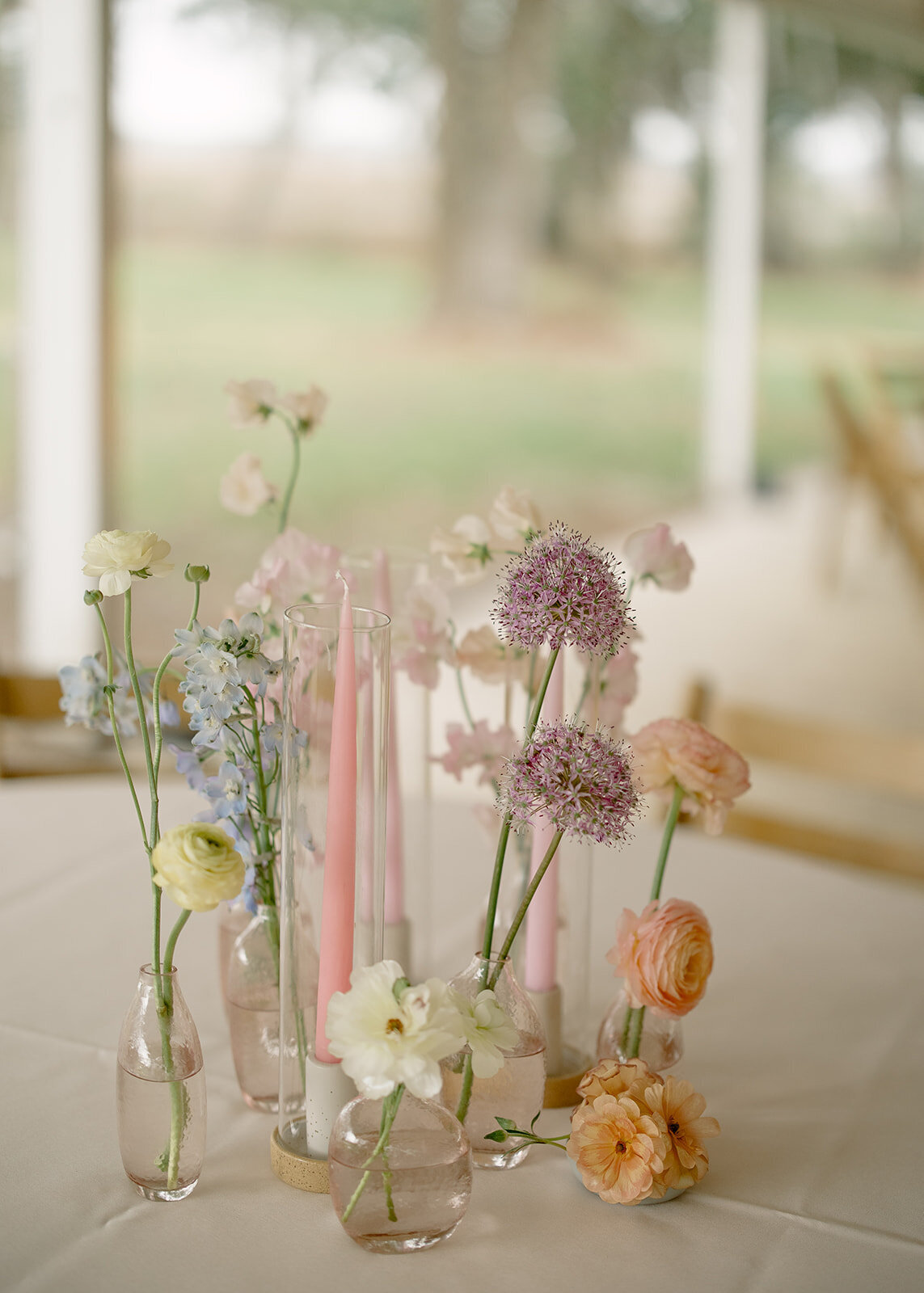 Pastel colored candles and flowers on a wedding reception table