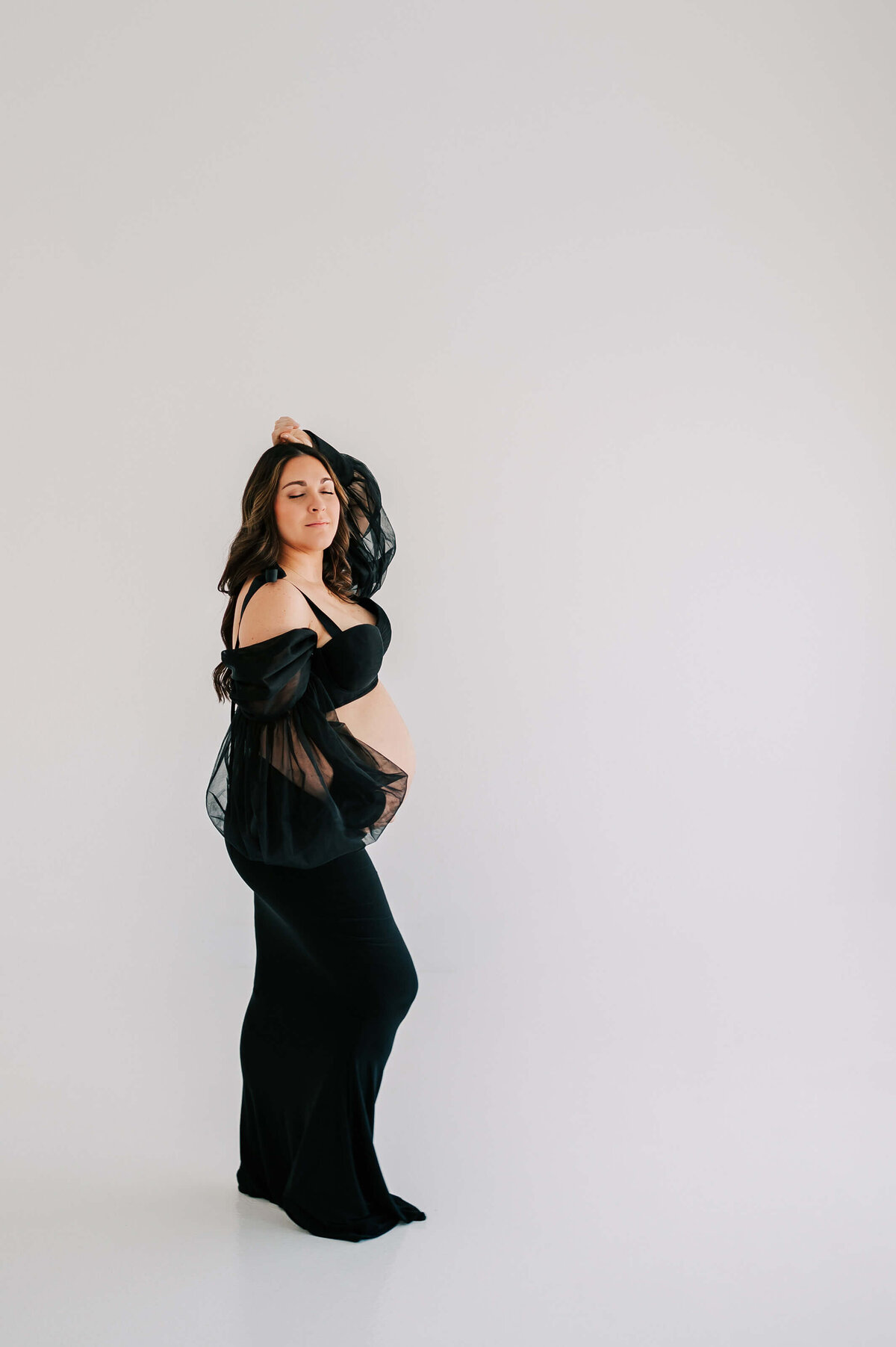 pregnant mom closing eyes in studio enjoy maternity photography in Joplin MO