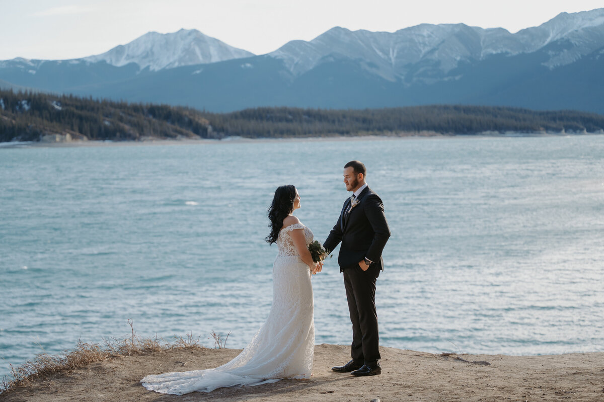 Mountain elopement photo of bride and groom on their beach interacting