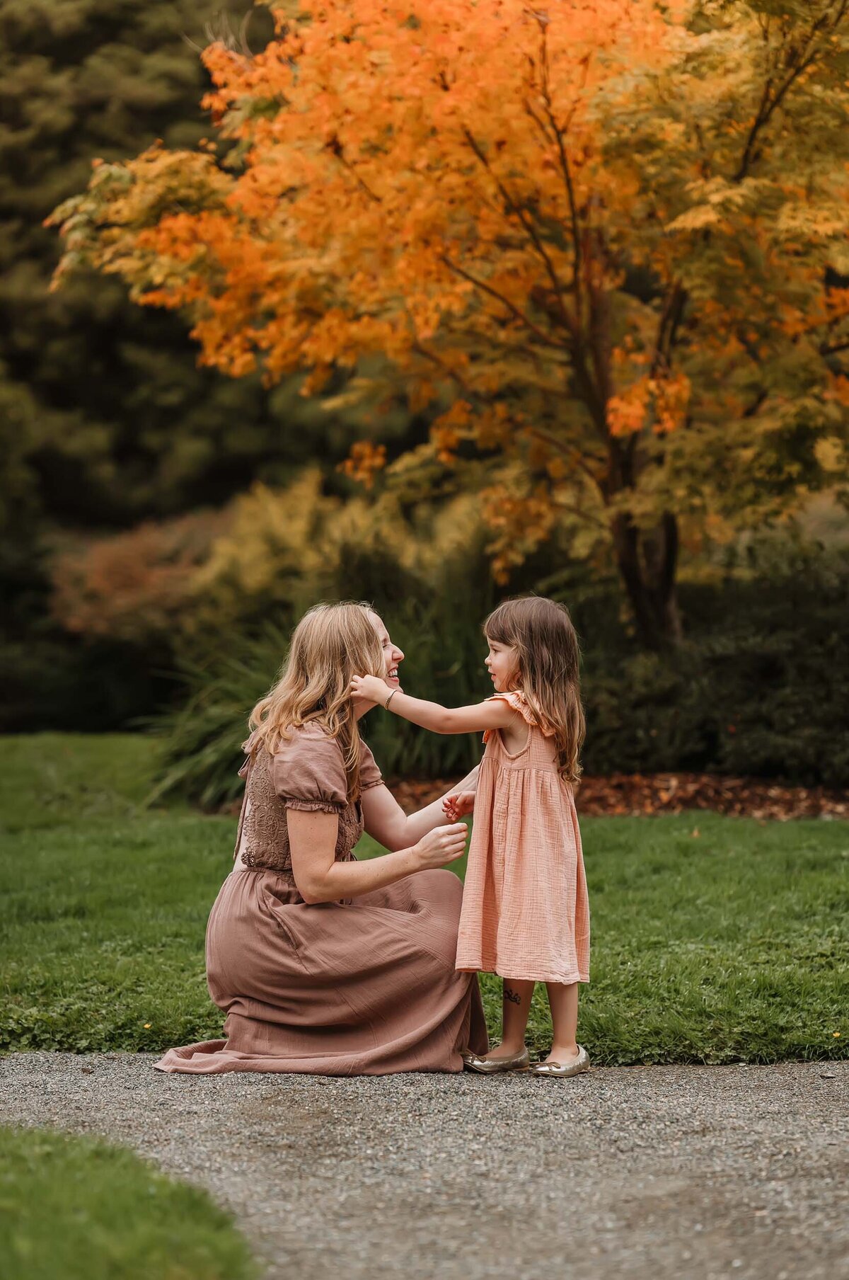 Sweet moment of a girl gently touching her mother's hair, showcasing the bond between them during a tender family session.