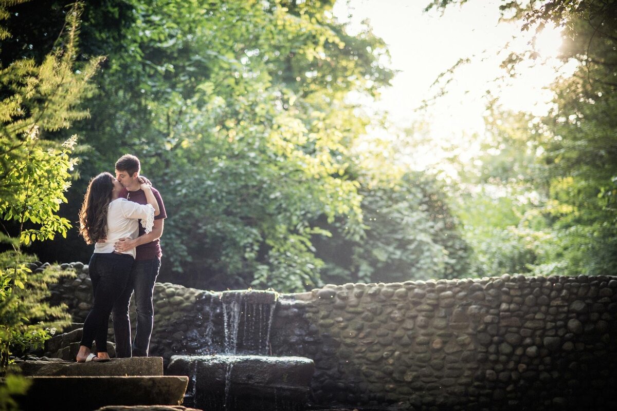 couple kiss in front of waterfall at canton garden center