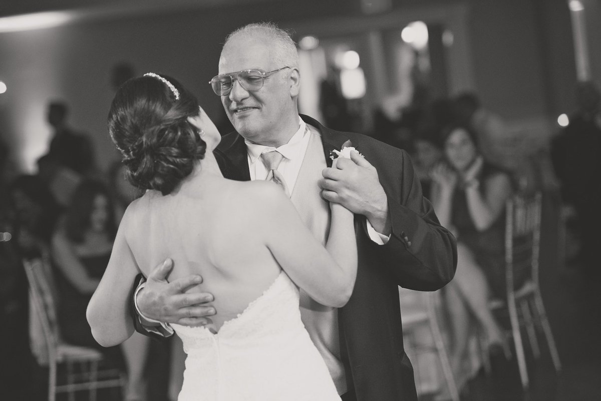 black and white photo of dad dancing with bride during wedding reception at Lawrence Yacht and Country Club