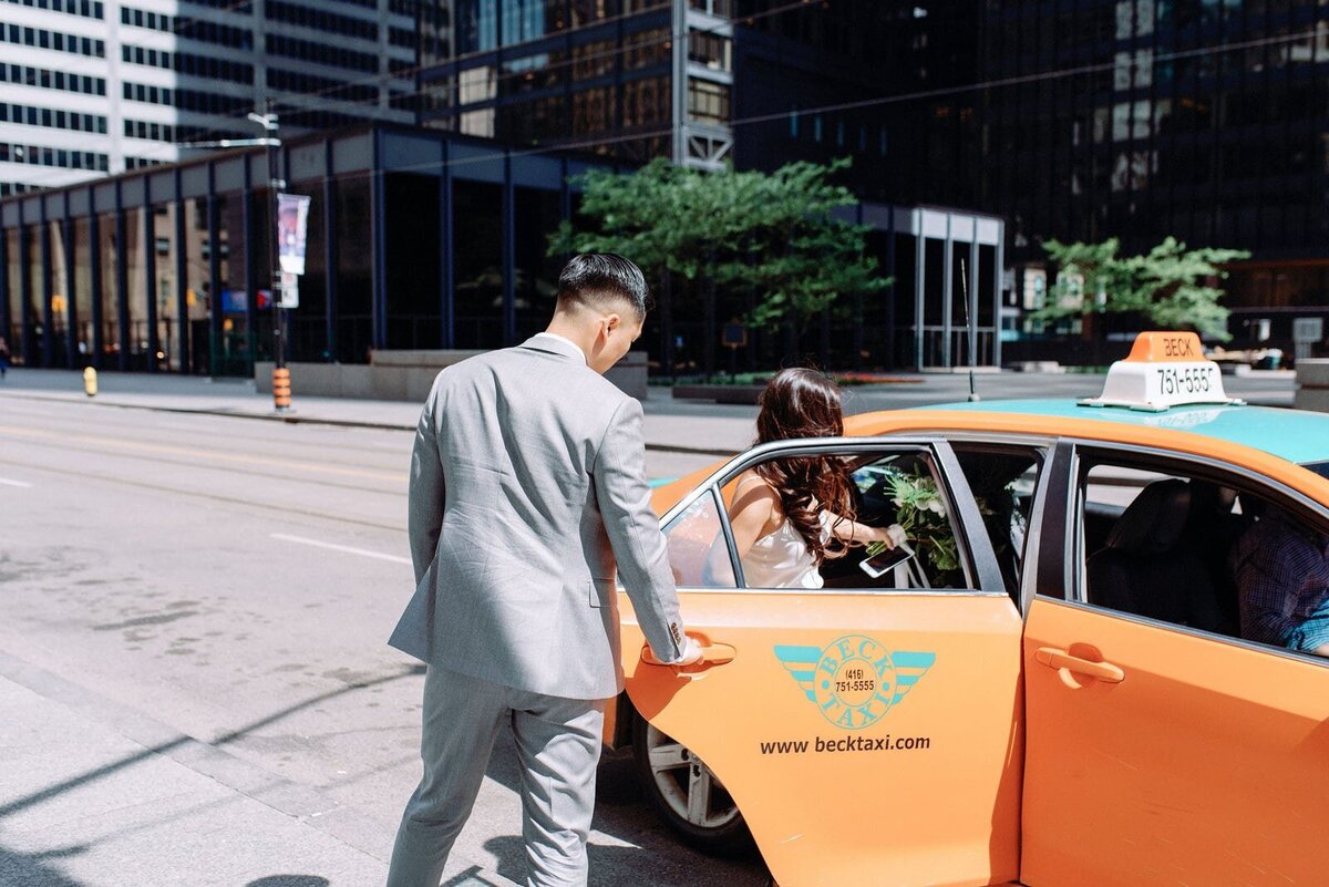 Bride and Groom hails cab on wedding day to hotel ocho toronto wedding jacqueline james photography
