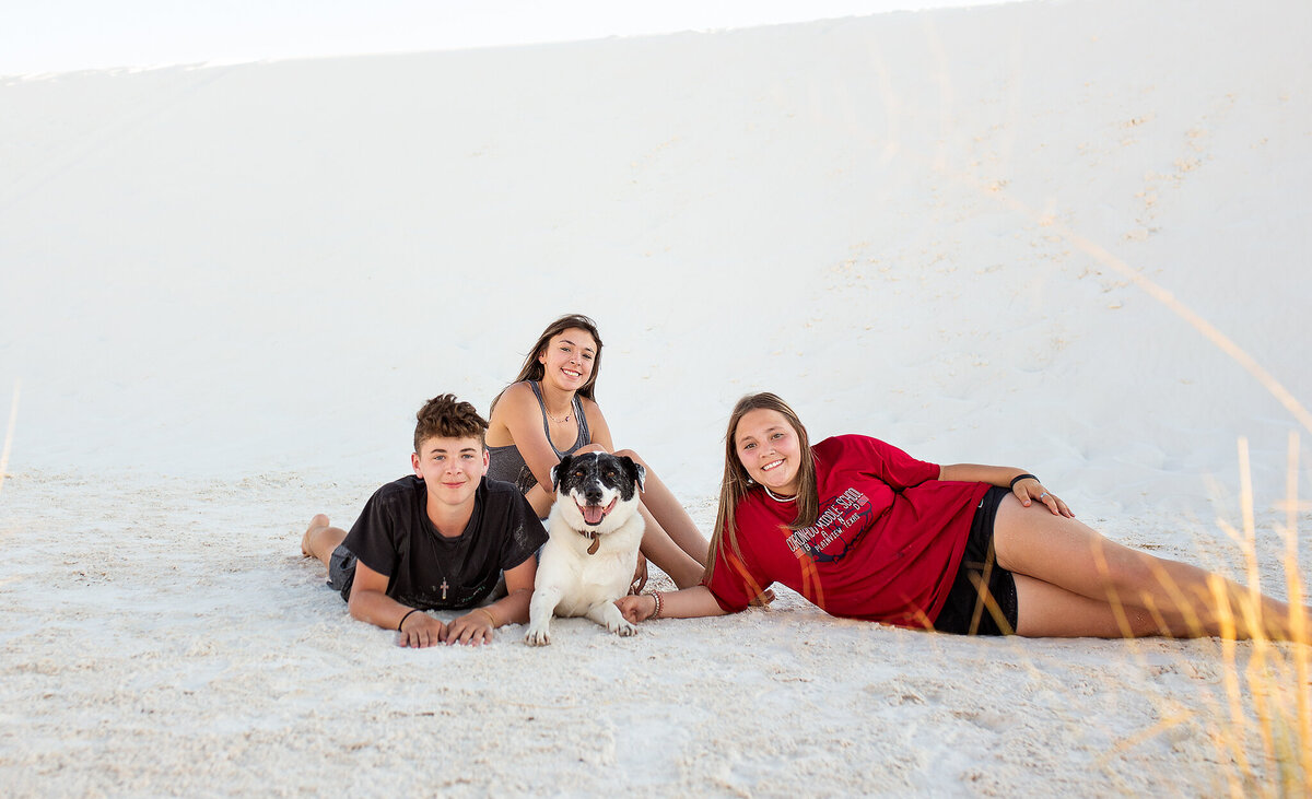 Kids and dog laying in the sand at White Sands National Park NM