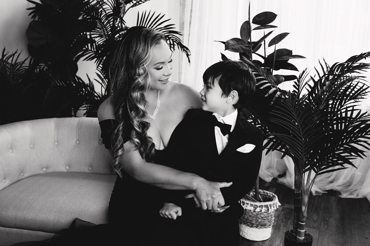 st-louis-family-photographer-mom-and-son-looking-at-each-other-on-couch-with-plants-in-black-and-white
