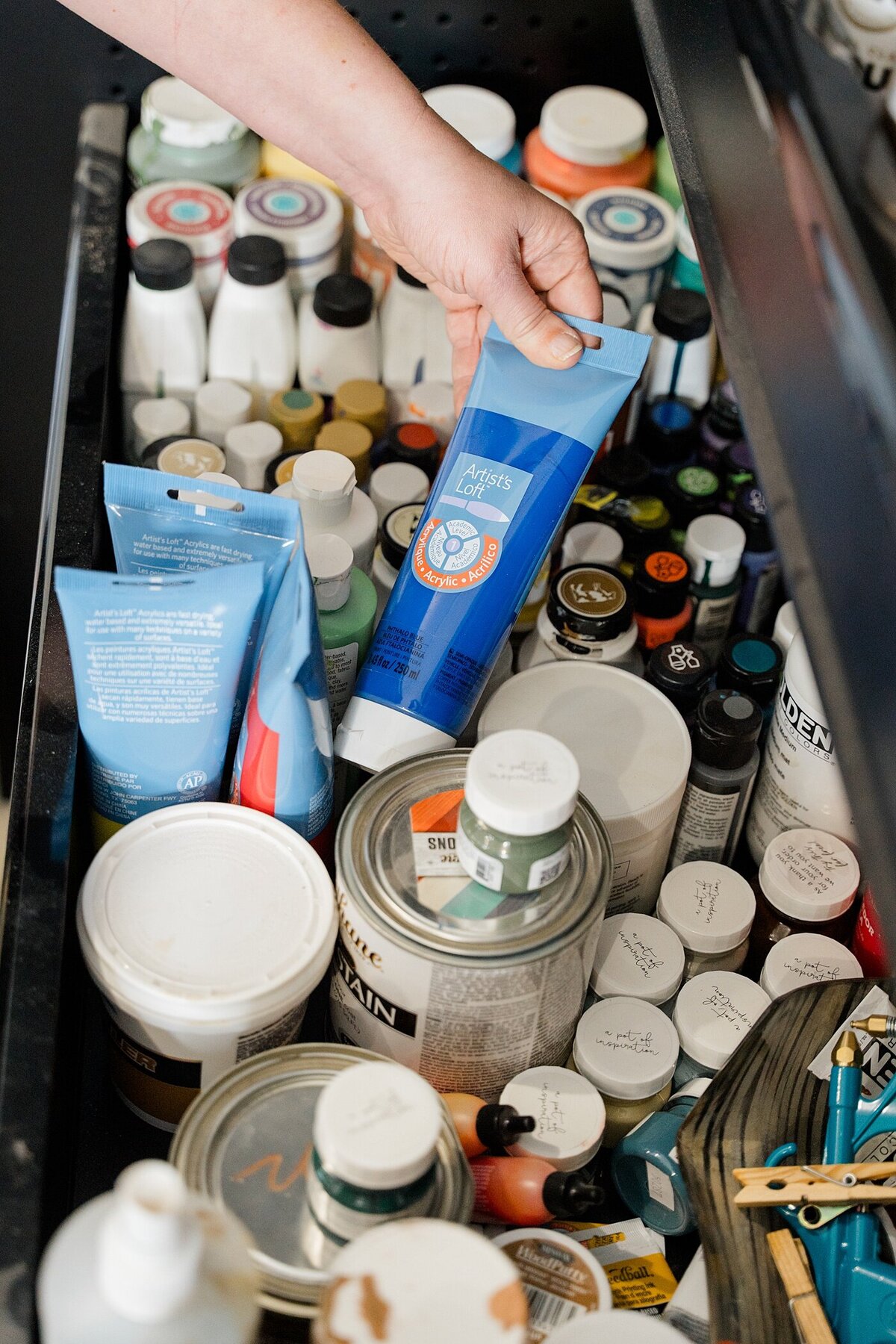 supply box with paints and stains with person taking out a paint tube photographed by Columbus photographer