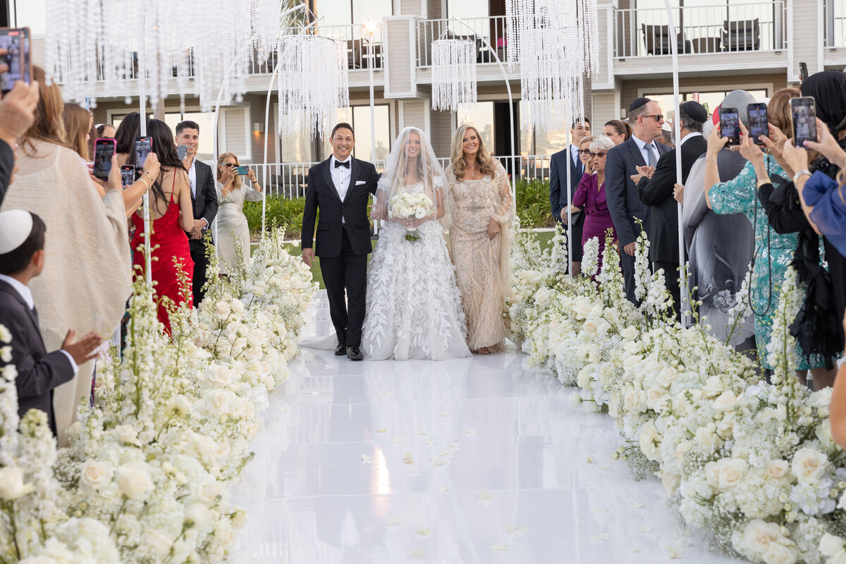 A bride walking down the aisle with her parents