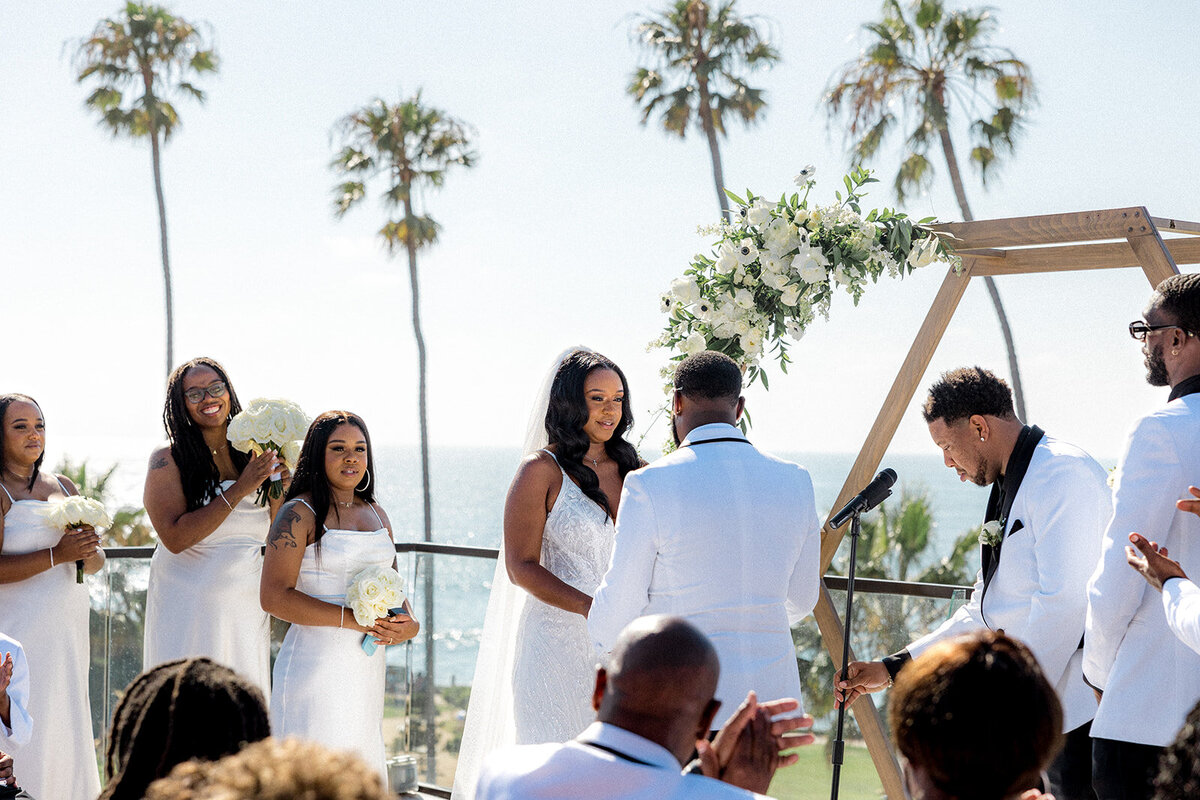 Bride and groom at the alter at their San Diego wedding with bridesmaid in the background
