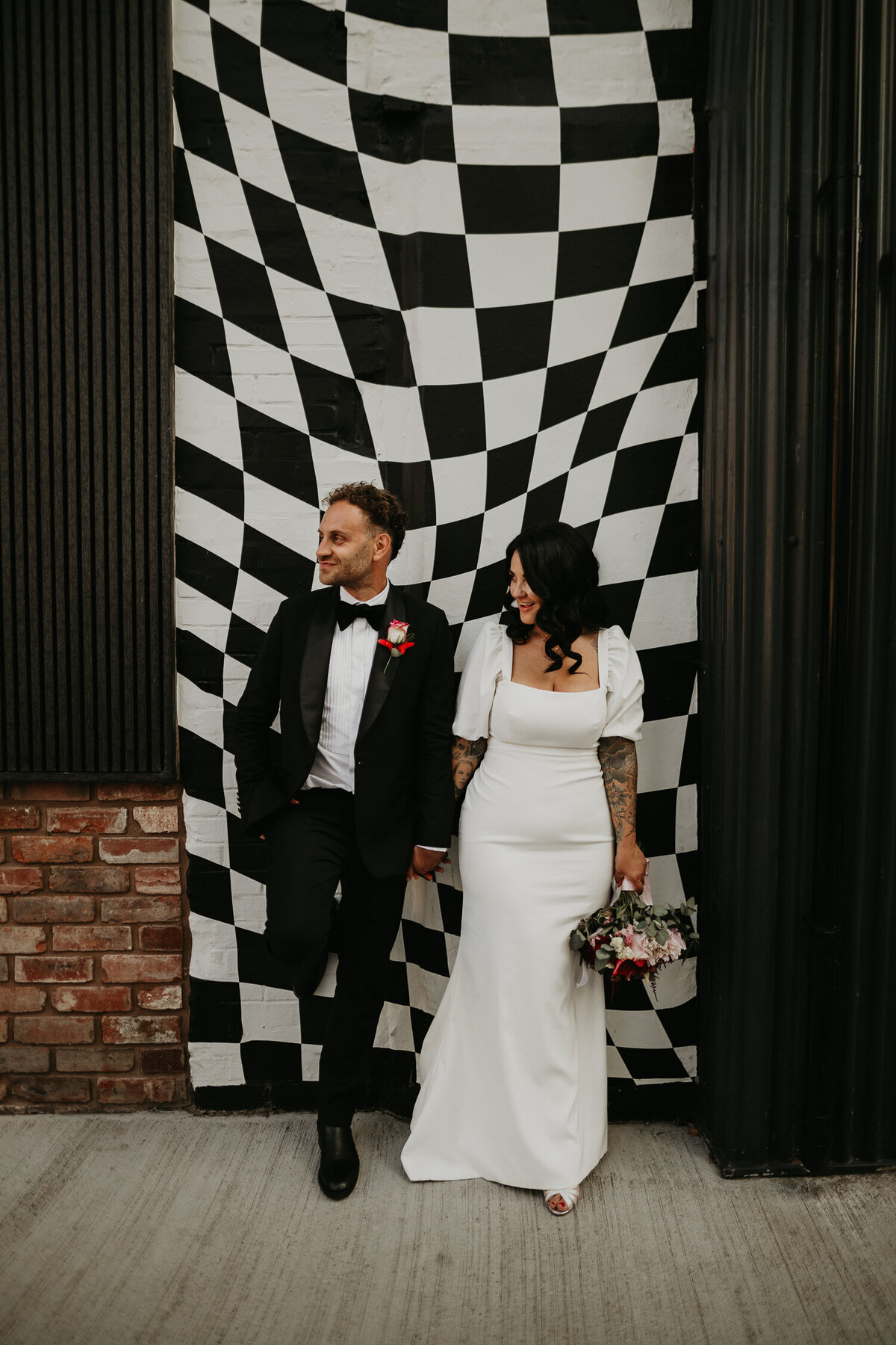 An Elder Emo couple stand outside the monochrome mural at The Shack Revolution.