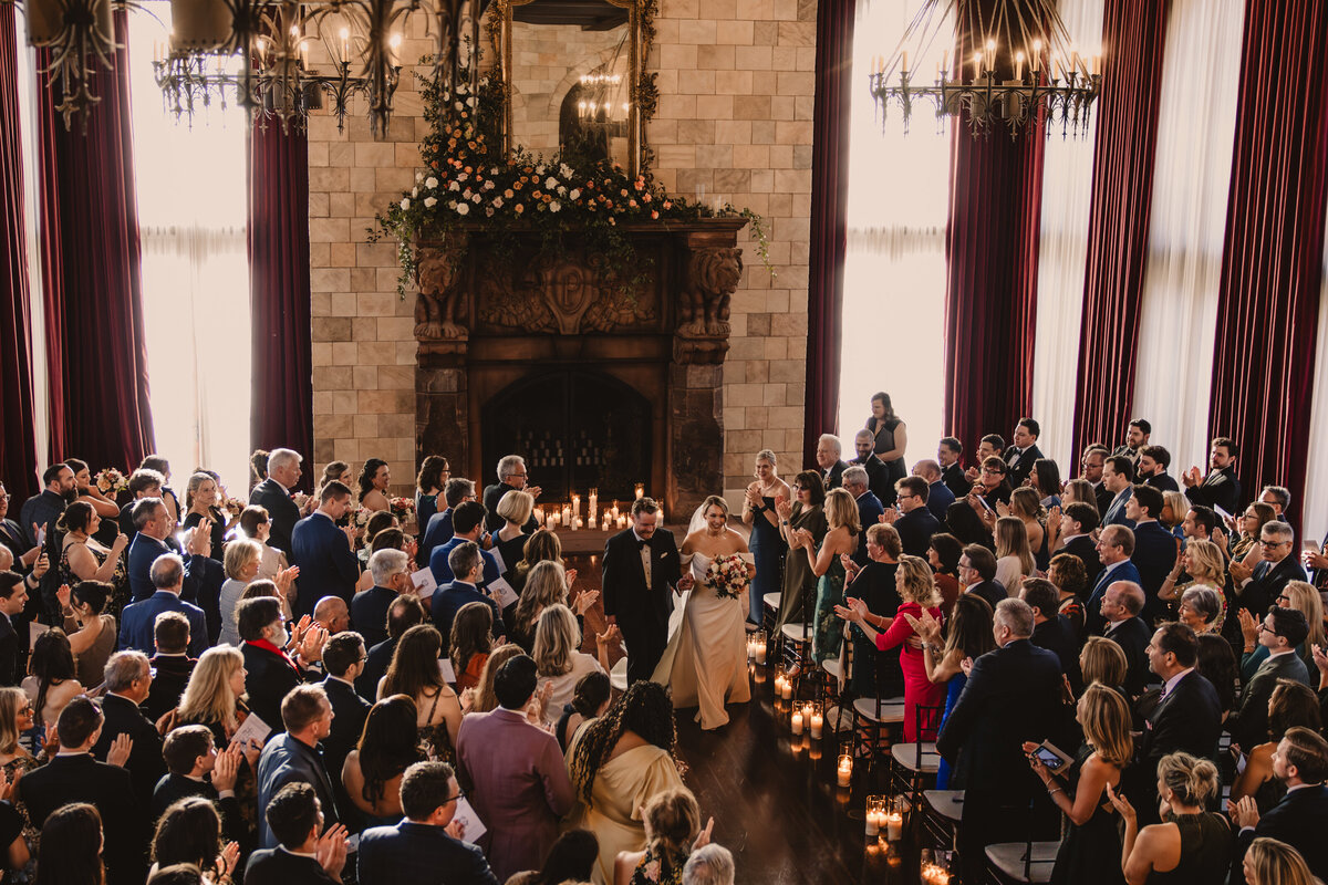 View looking down on a wedding ceremony as newlywed walk back up the aisle 