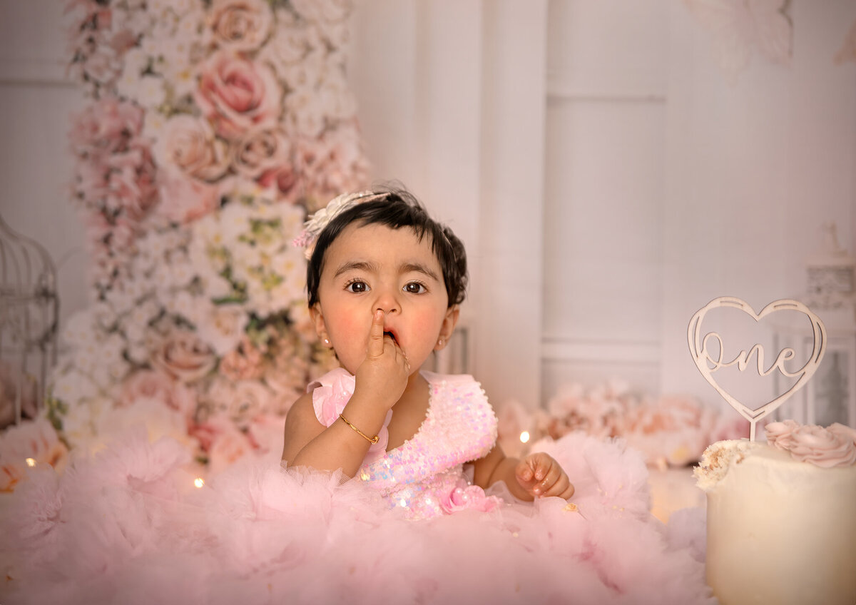 Smiling baby covered in frosting during custom cake smash shoot – Sonia Gourlie Studio