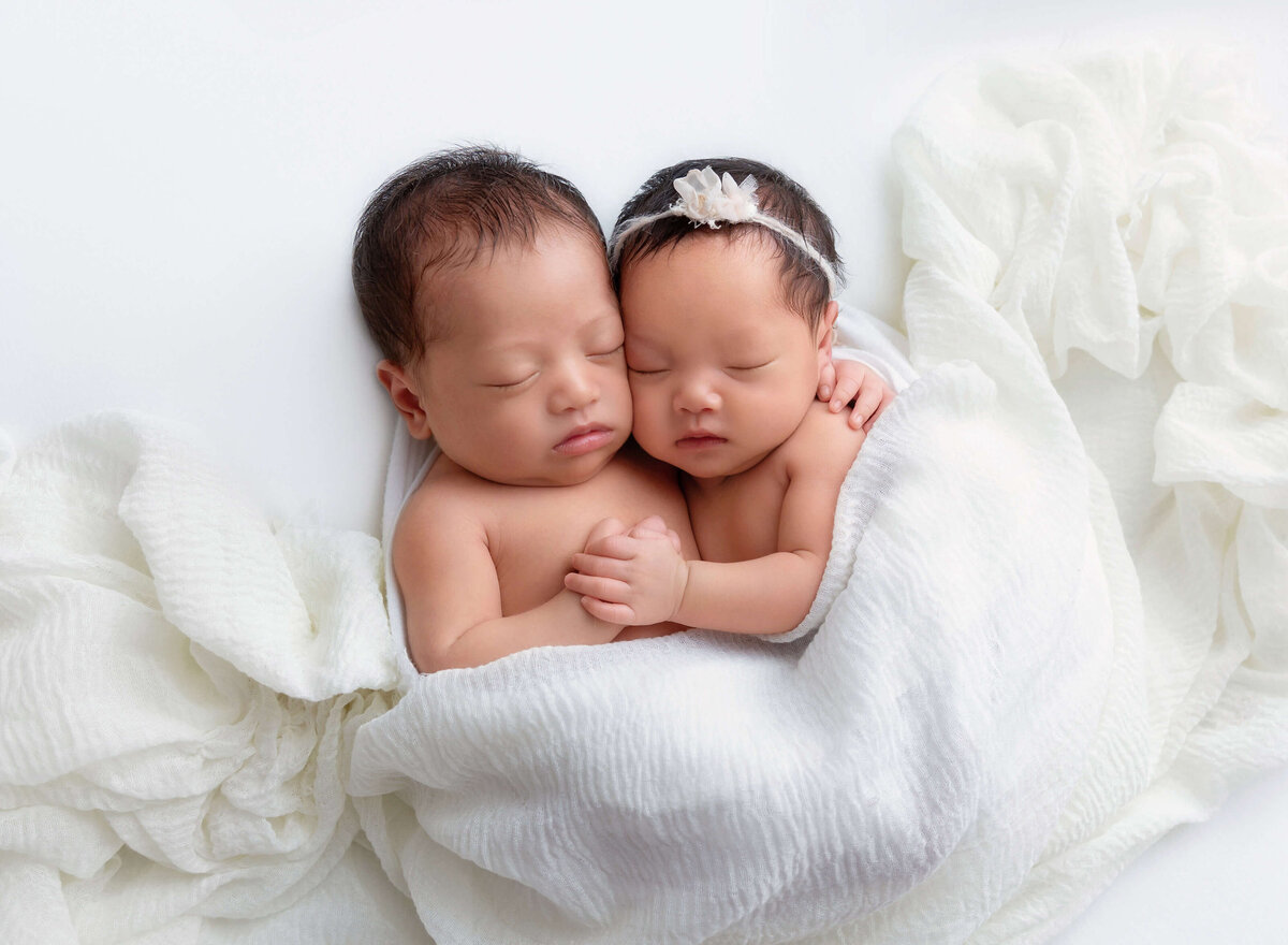 Adorable newborn twins sleeping together during a professional baby photography session in  New York City