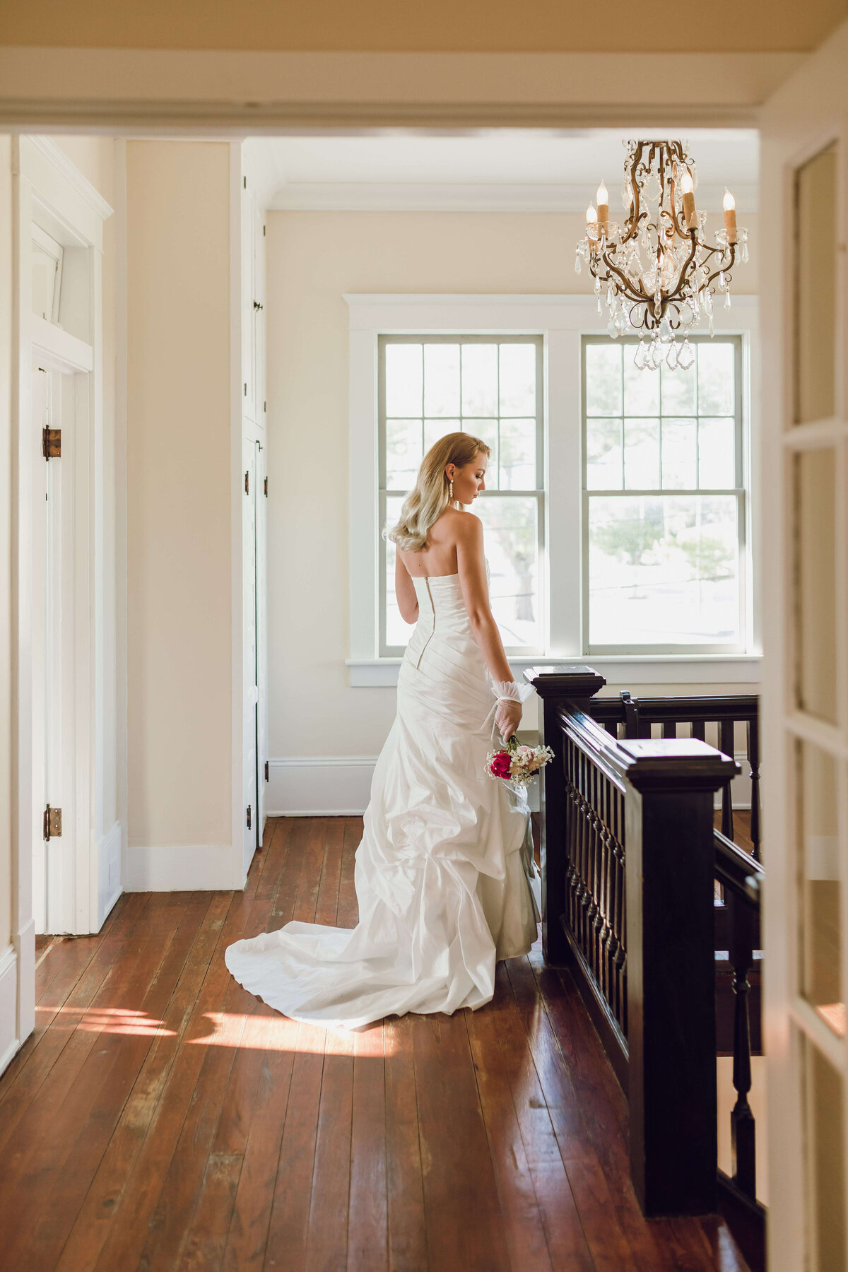 bride framed by staircase & windows at sapp house in downtown panama city fl