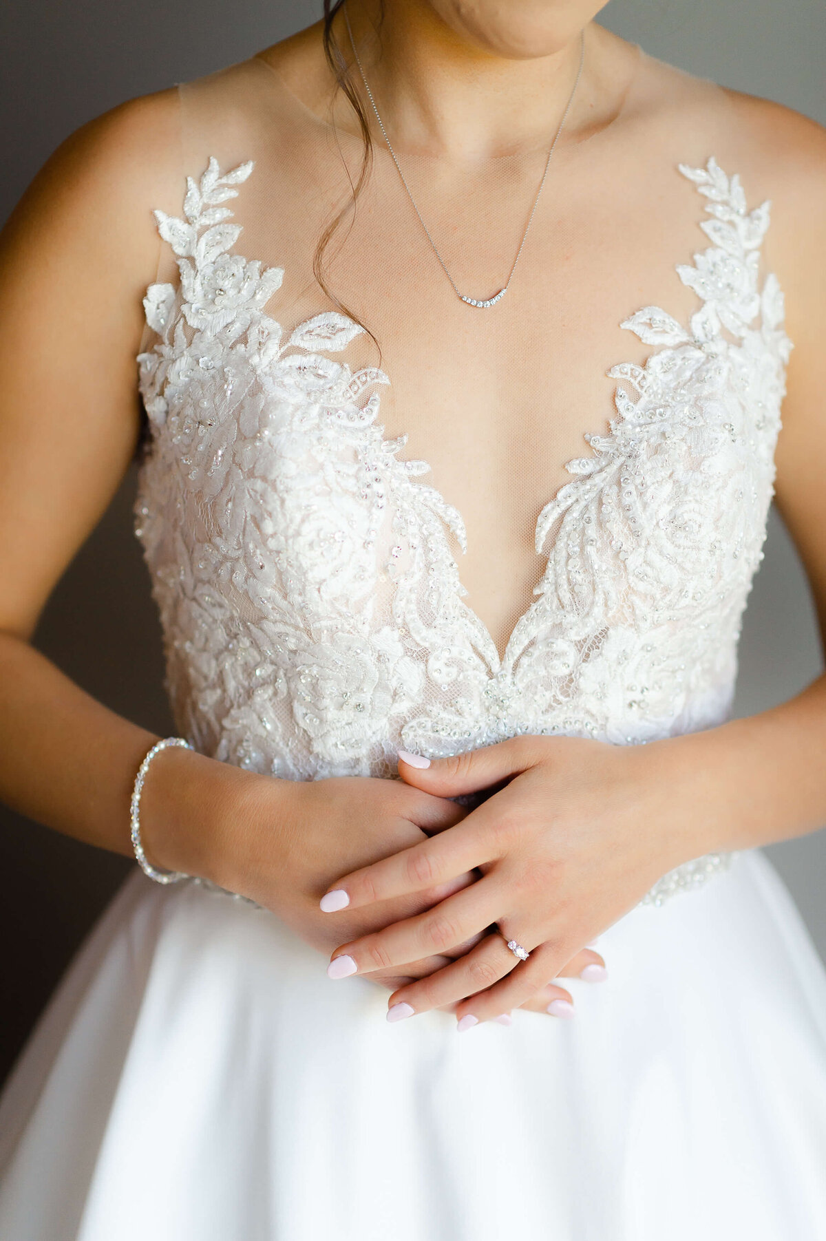 Ottawa wedding photography showing the close up details of a bride's gown, bracelet and engagement ring taken at the Brookstreet Hotel