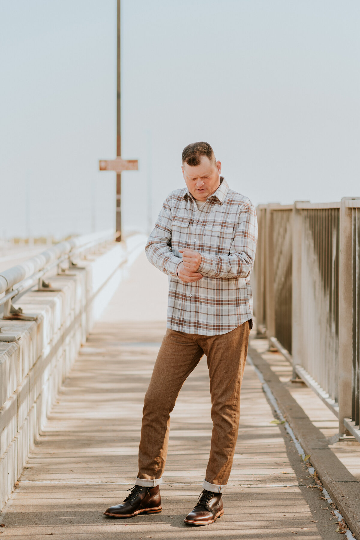 Active dating profile photo of a man walking confidently on a Minneapolis bridge in casual style, perfect for showcasing an adventurous vibe on dating apps.