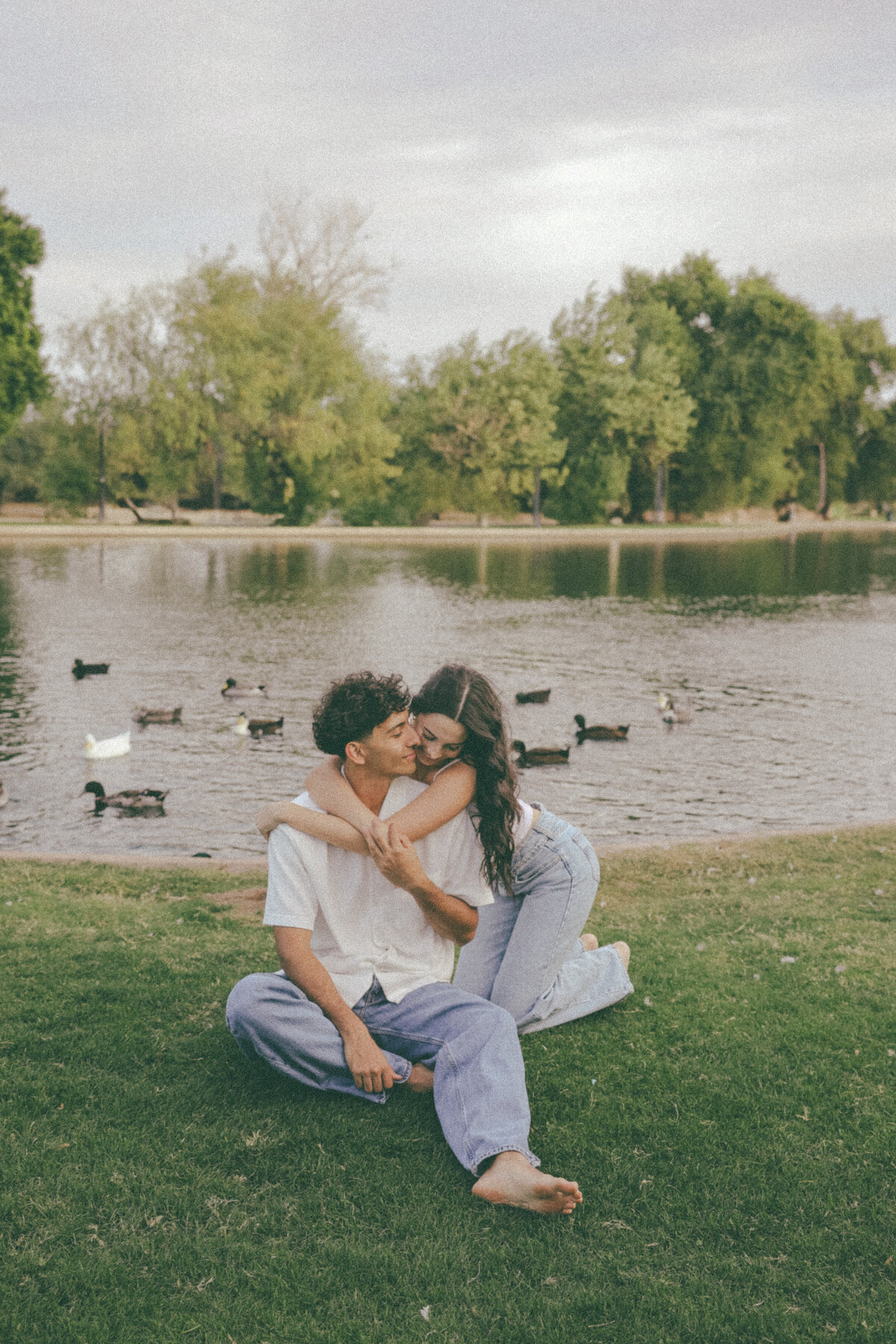 Playful Couple Embracing by the Lake During Sunset Engagement Photos