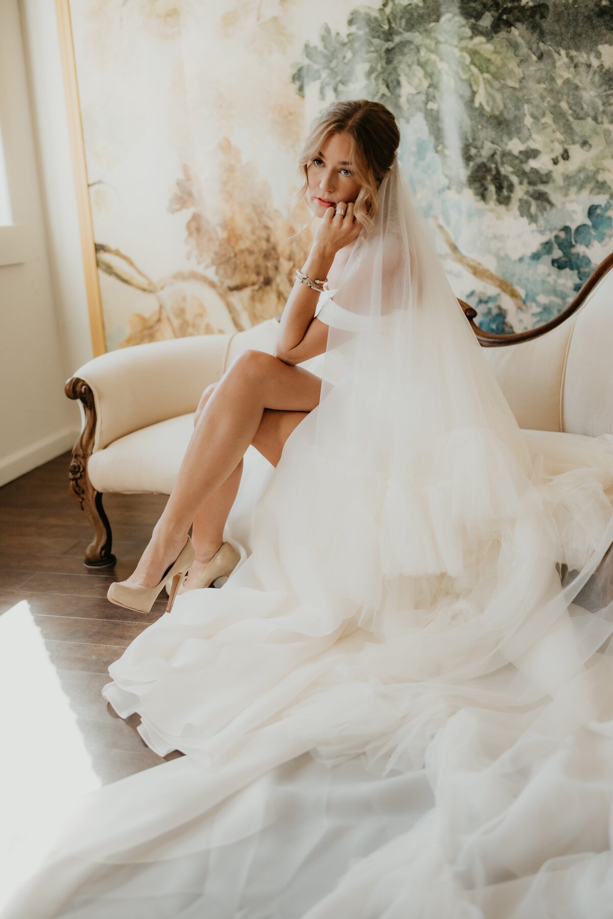 bride sitting in wedding dress on couch, studio portrait session in canyon texas