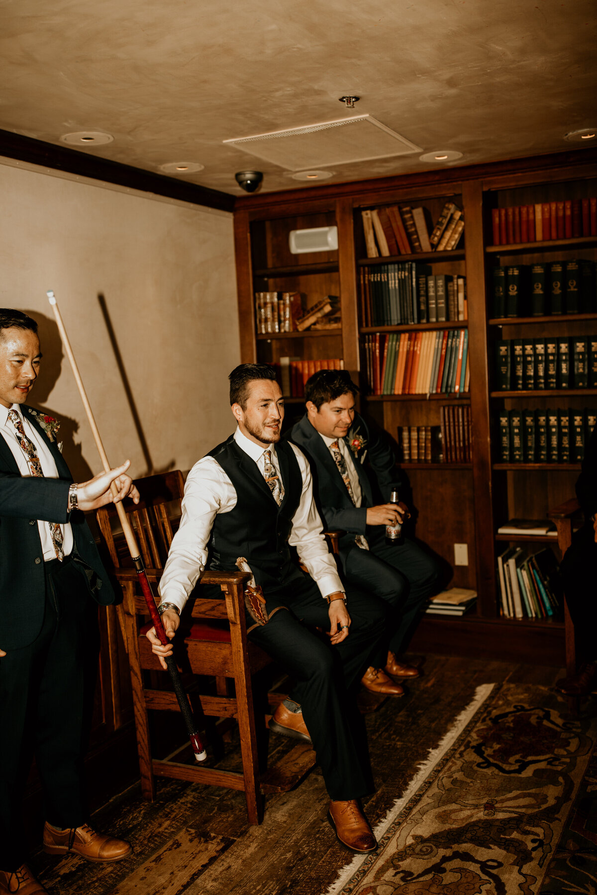 groom playing pool with buddies before wedding ceremony