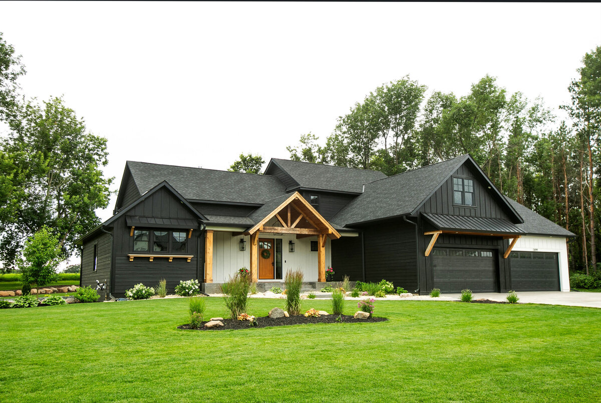 Exterior view of custom home in Otsego, Minnesota with modern wood details and front porch built by Cornerstone Custom Builds