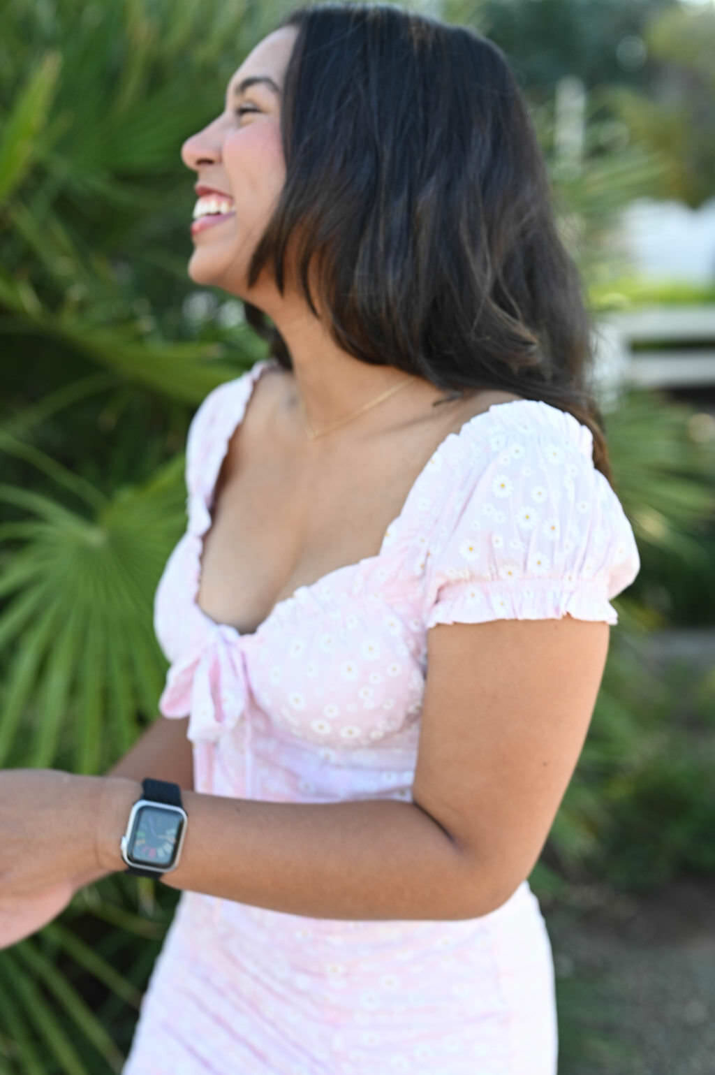 A person in a pink dress laughing.