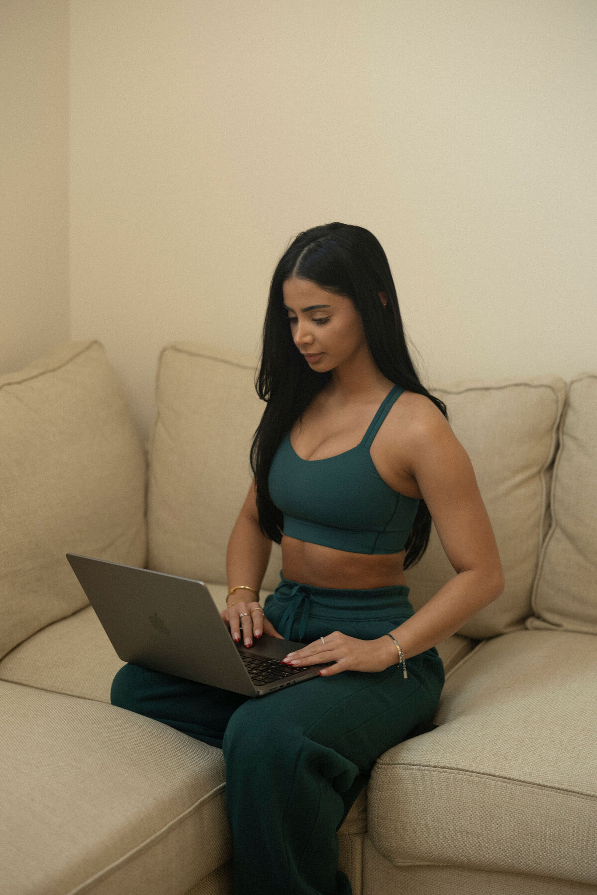 Close-up of a client sitting on a couch using a laptop to review the terms and conditions for Synergy EMS services.