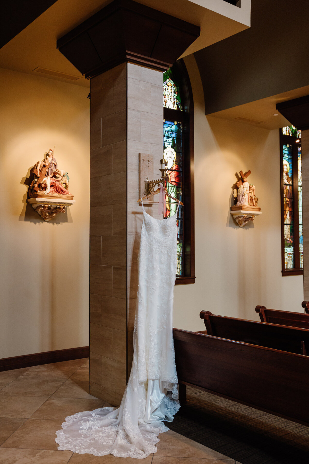 A wedding dress hanging from a pillar in a church