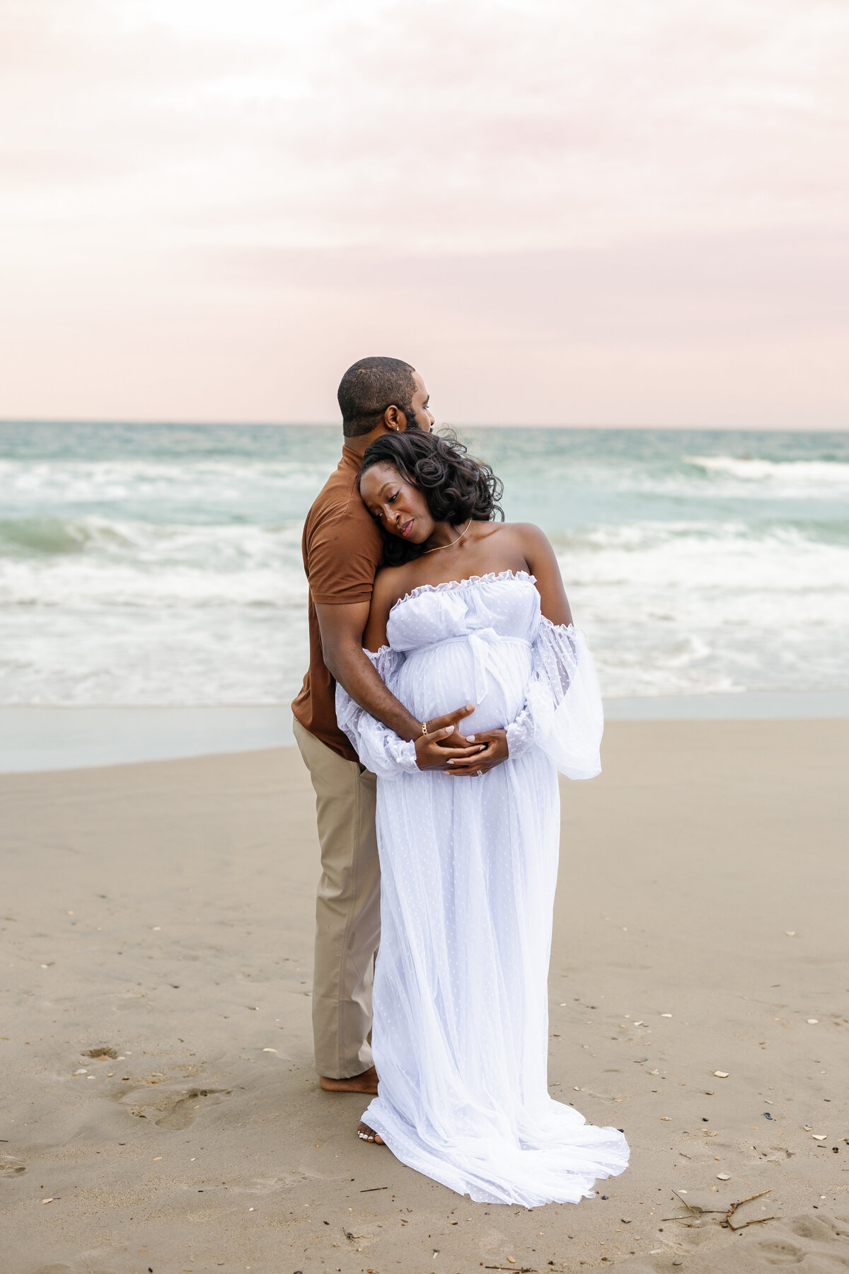 Expectant mother in flowing dress on Fort Fisher beach, golden hour maternity photos in Wilmington