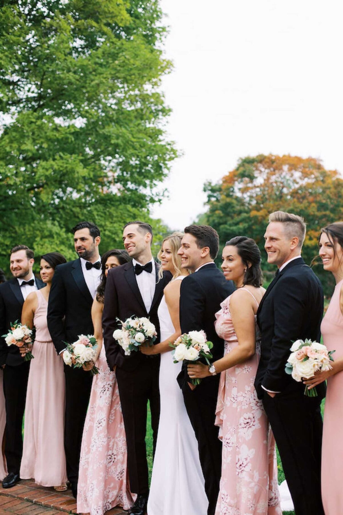 Wedding party in black tie and mixed prints before a luxury Chicago outdoor garden wedding.