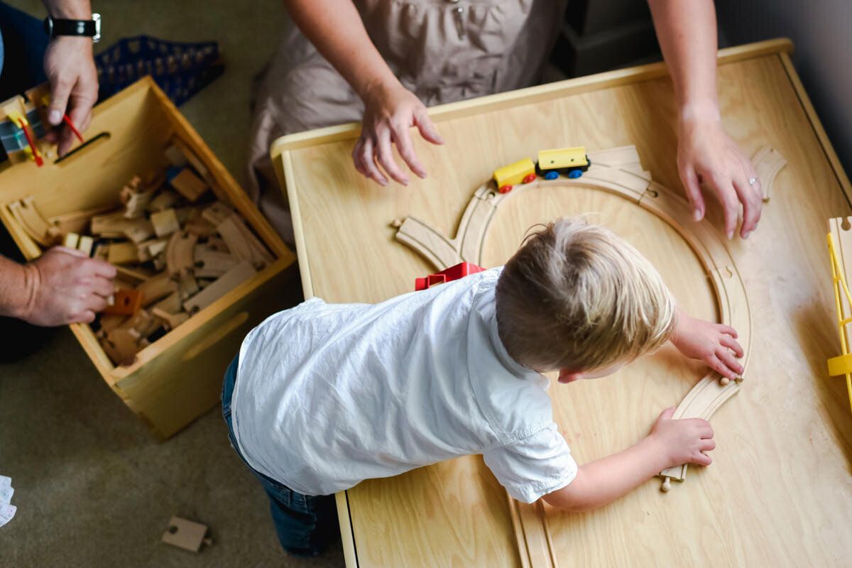 little boy playing with train set