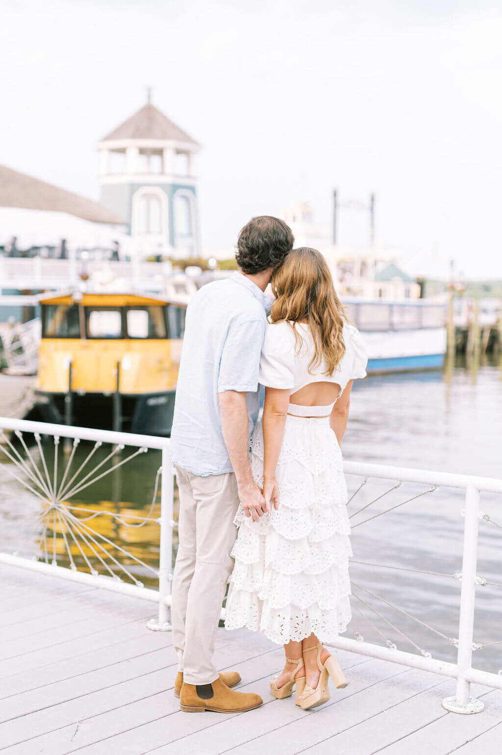 Couple looking out over a river in old town Alexandria during Engagement photos taken by Rachael Mattio Photography.