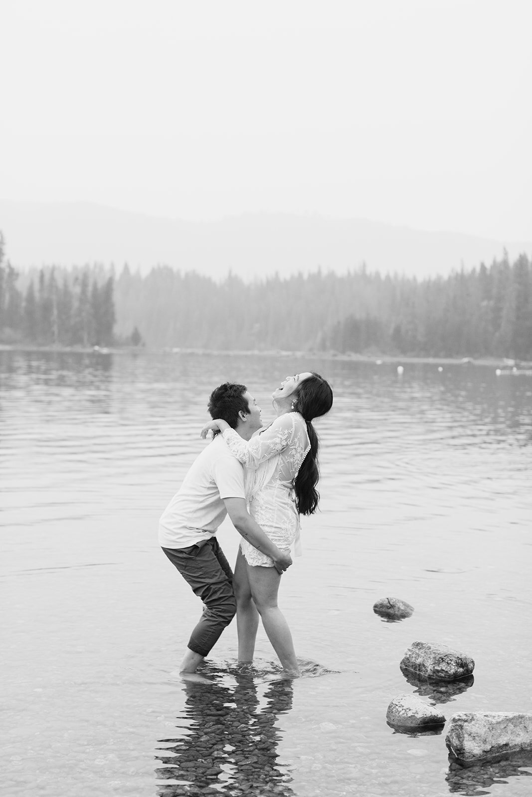black and white photo of a couple laughing in a lake