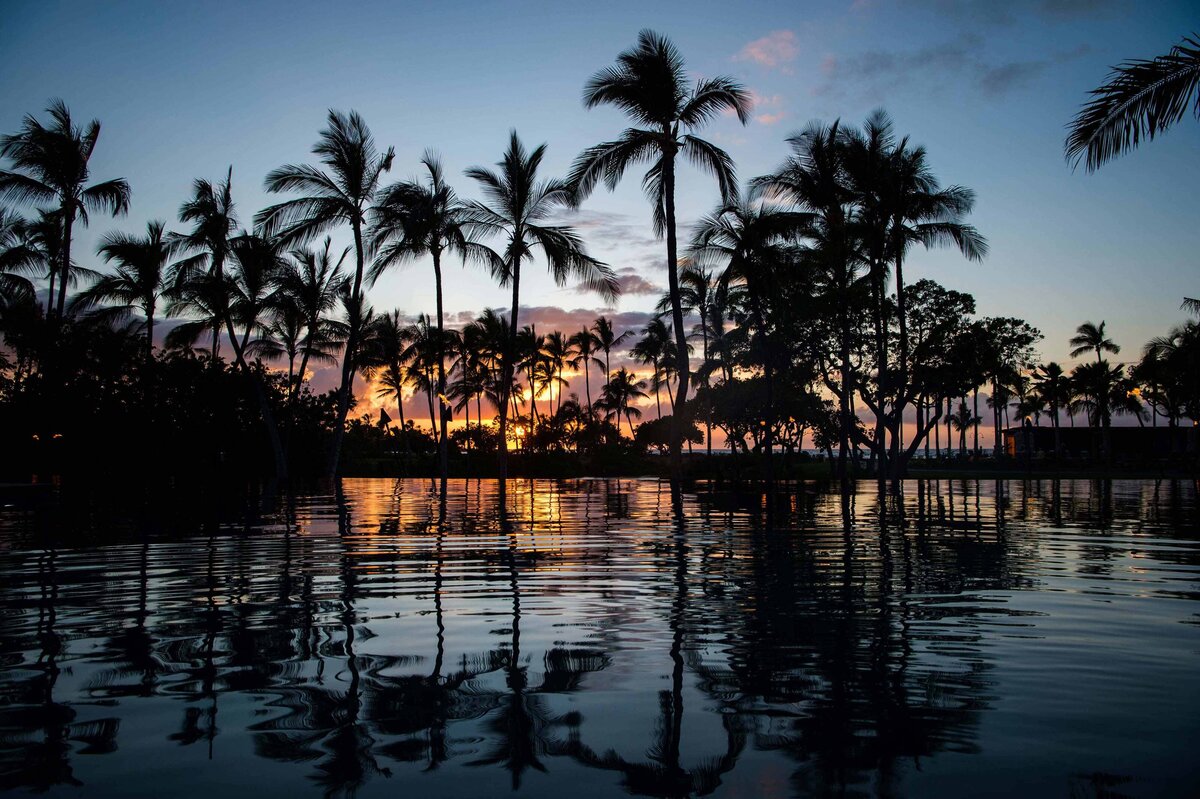 A pool at sunset with palms reflected to thow the scenery at the Mauni Lani  Hotel