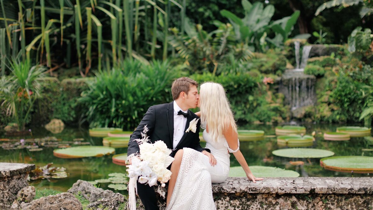 bride and groom kiss in a tropical garden on a wedding day