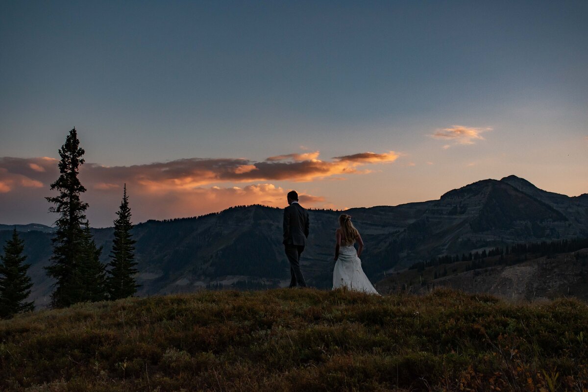 Enjoying the sunset at the end of their elopement on a mountain top