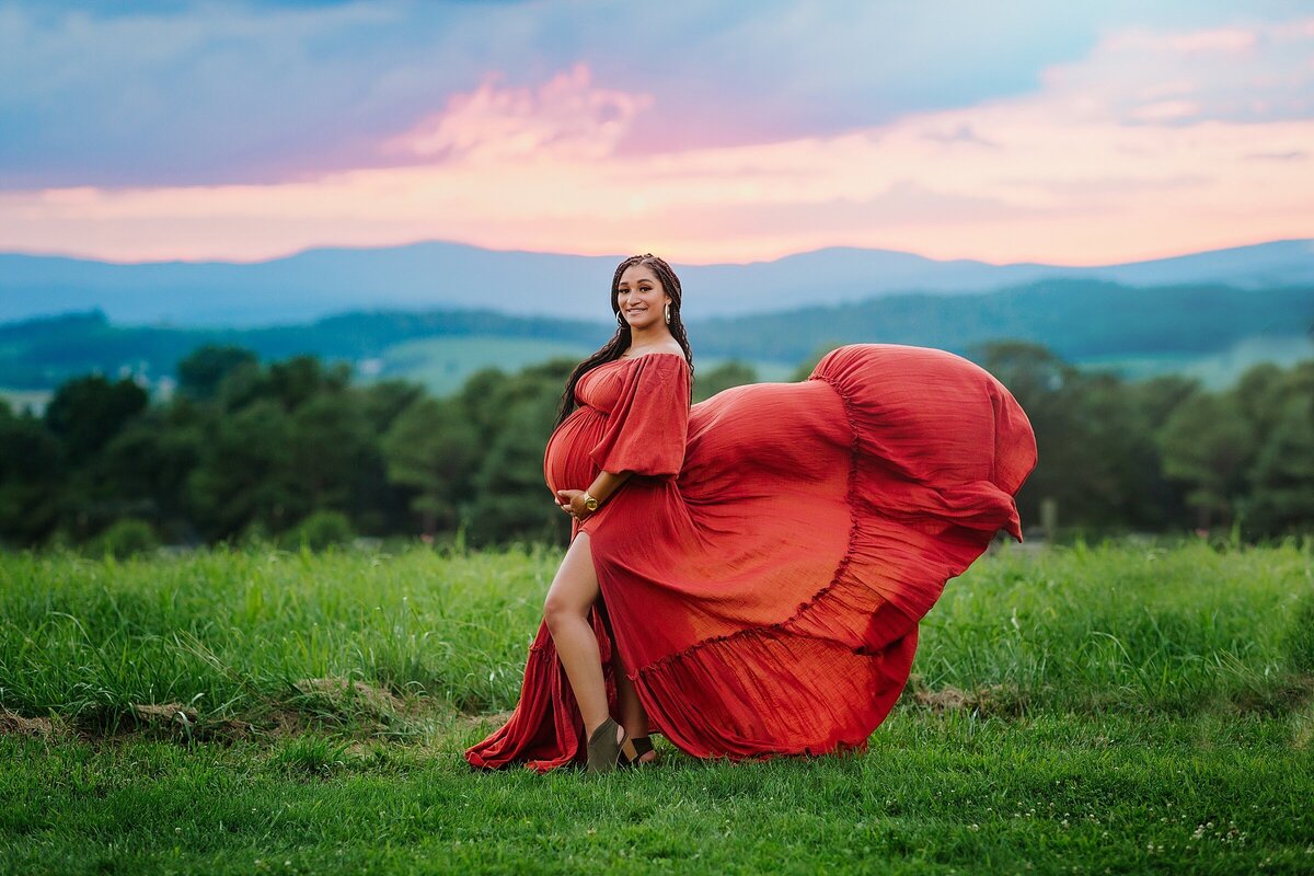 Sunset maternity session with mom wearing red gown at sunset