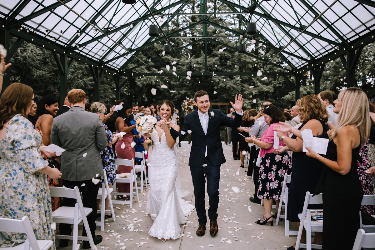 Bride and groom walking down the aisle at Hartwood Acres. 