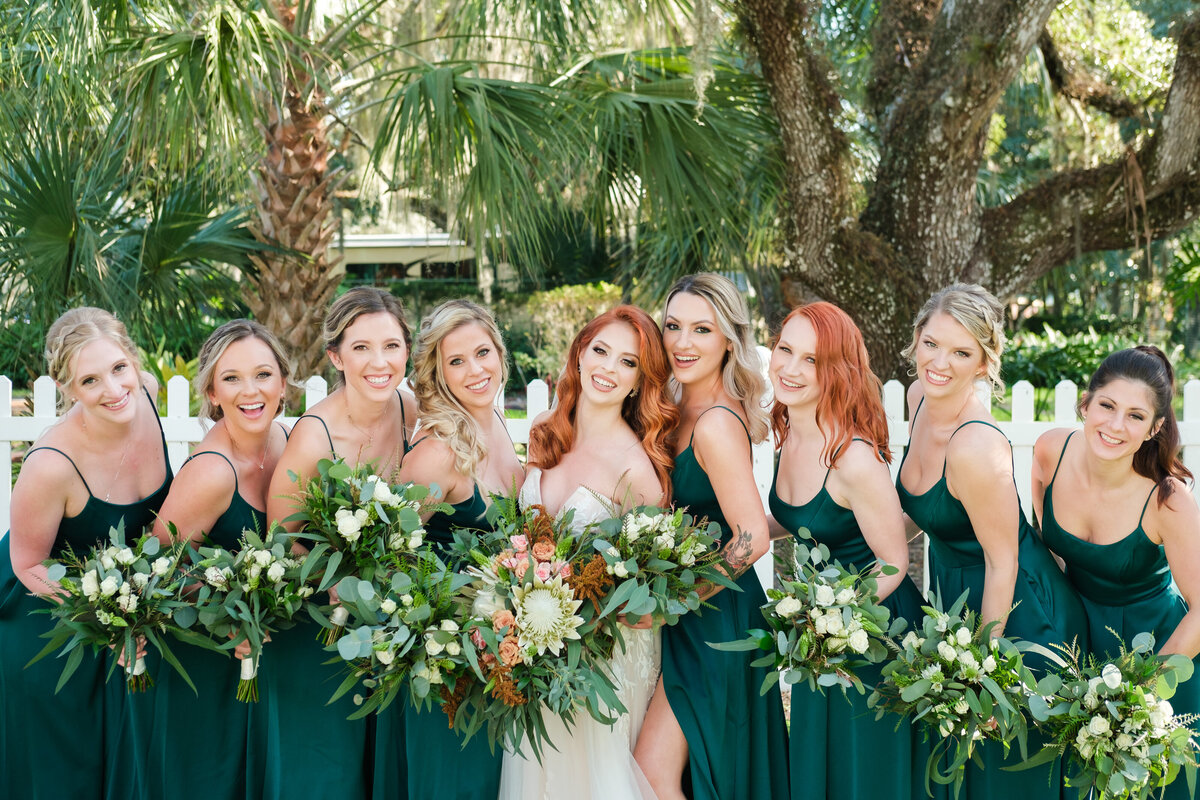 Bride and her bridesmaids holding green floral bouquets