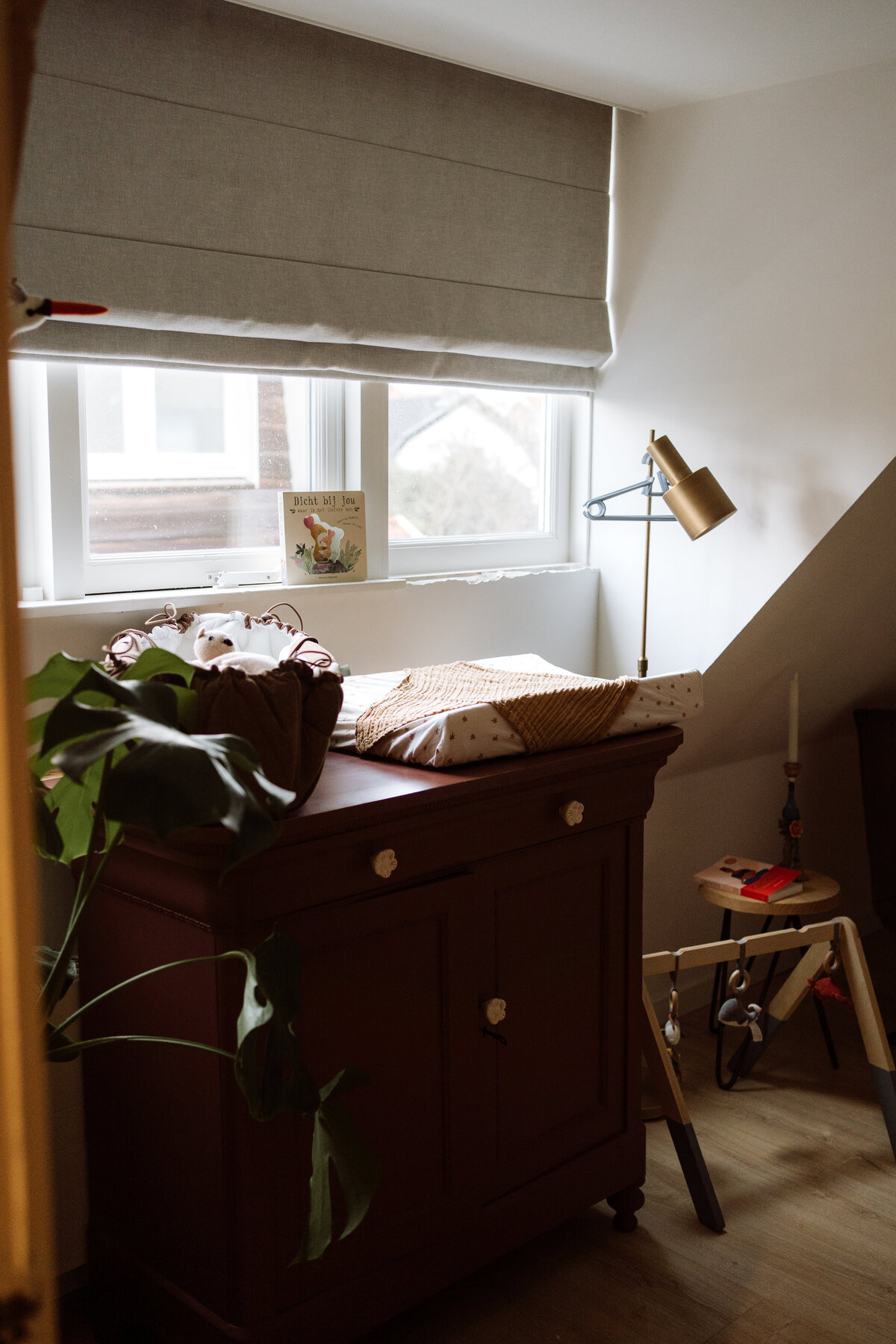 Sfeervolle zwangerschapsfoto van een vrouw met een prachtig zichtbare buik, vastgelegd in een warme en authentieke setting.