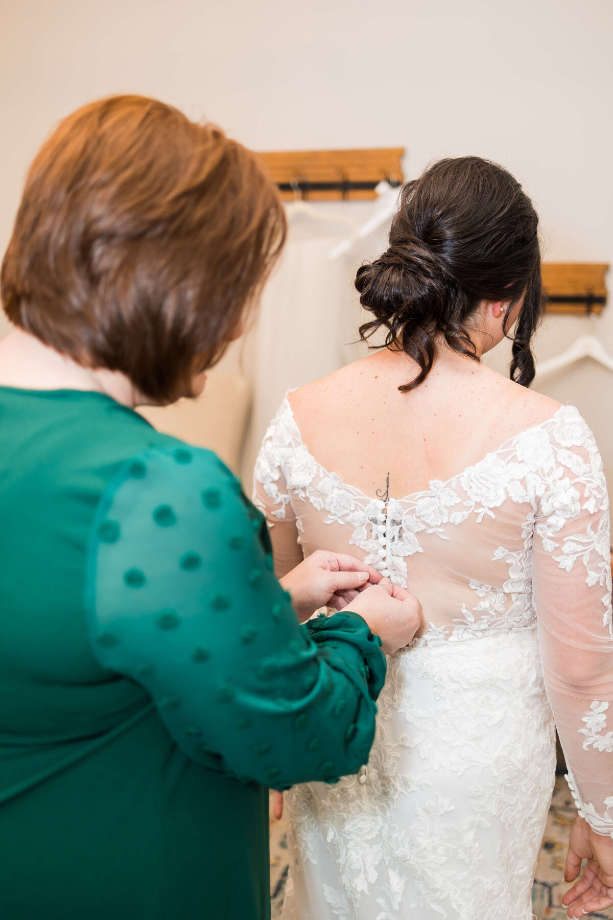 Mother fixing brides dress at at wedding at Mahr Park Arboretum, Tennessee