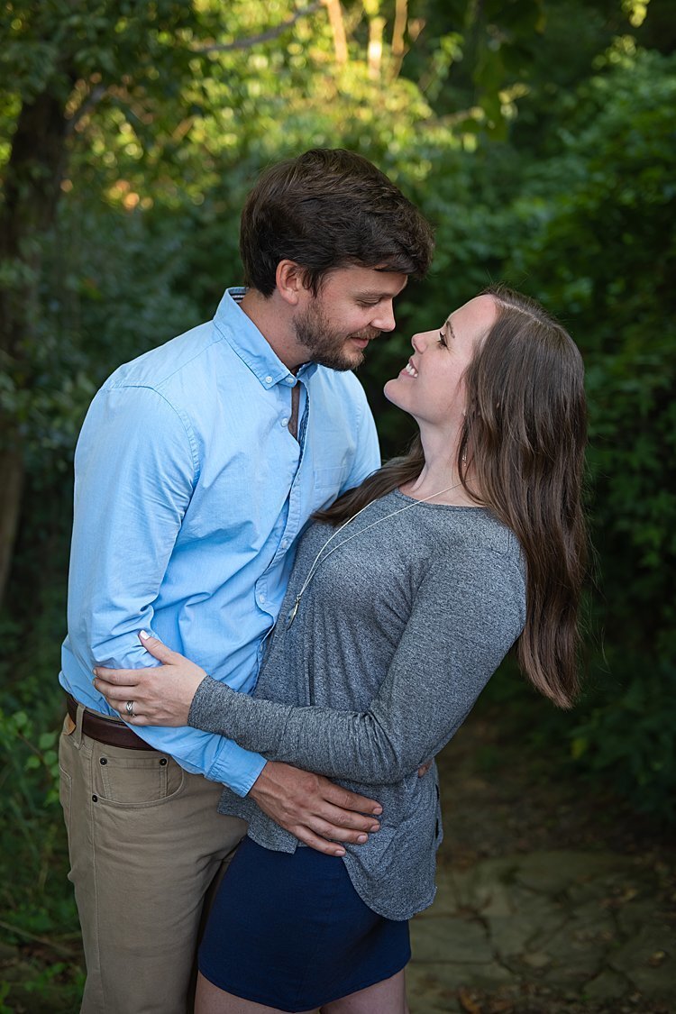 Fiancé dips bride-to-be during their engagement session in a wooded area in Pittsburgh, PA