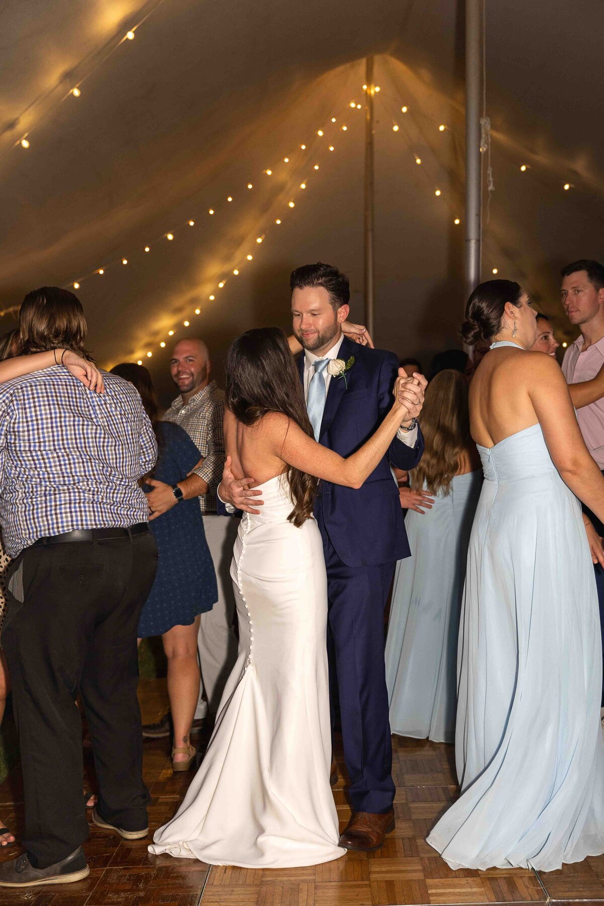 Groom smiling at bride while dancing together at wedding reception