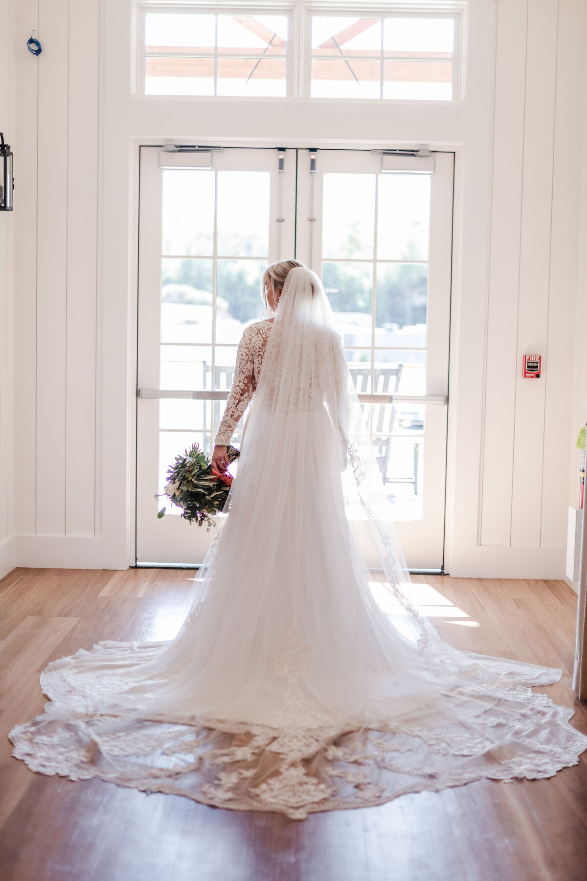 Bride standing in the window at the Lakehouse with lacy veil