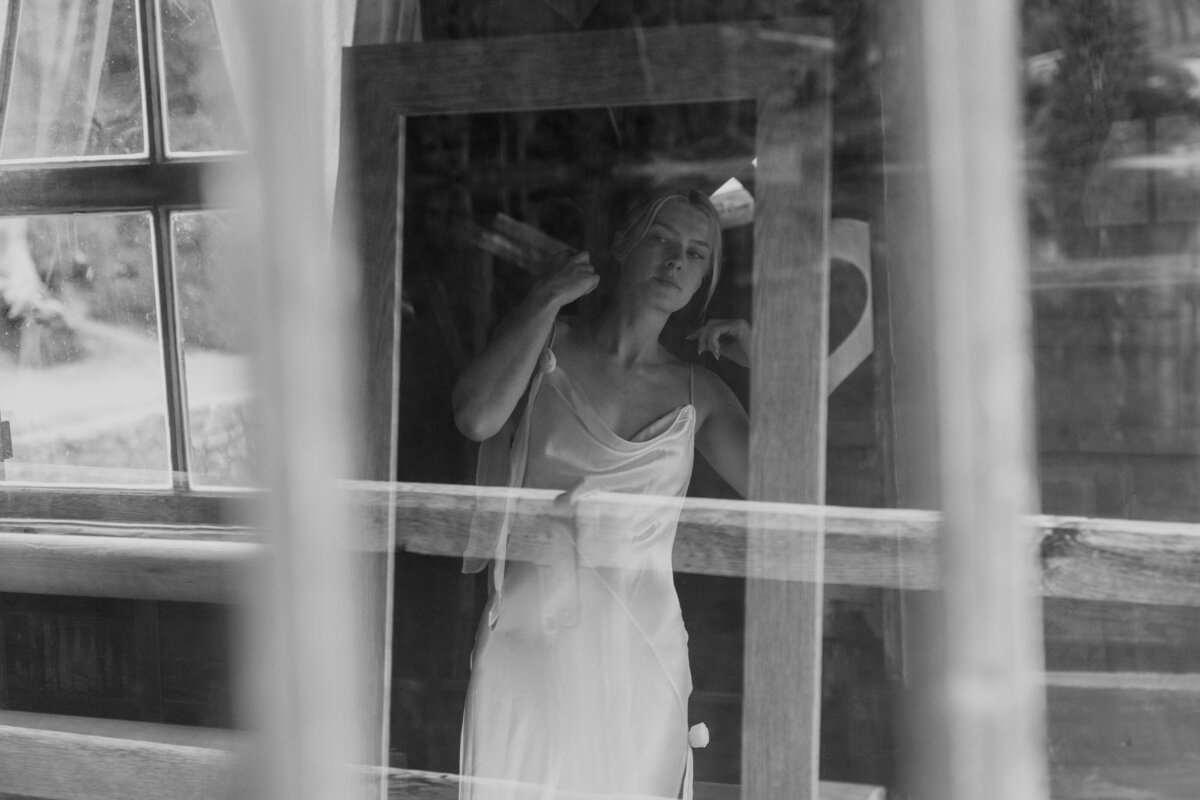 Bride adjusting veil in black and white photo