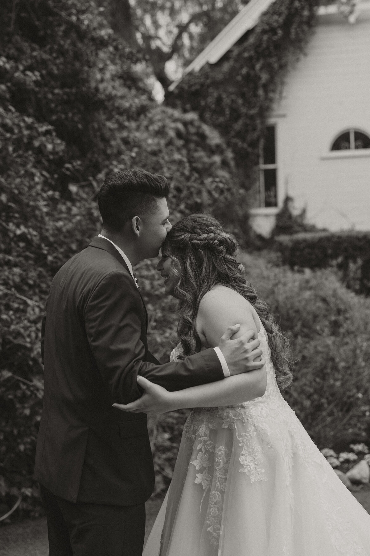 bride and groom embracing, bride crying while groom kissing her head