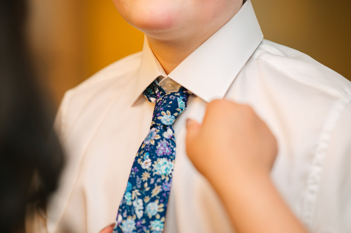Person helping bride's tie