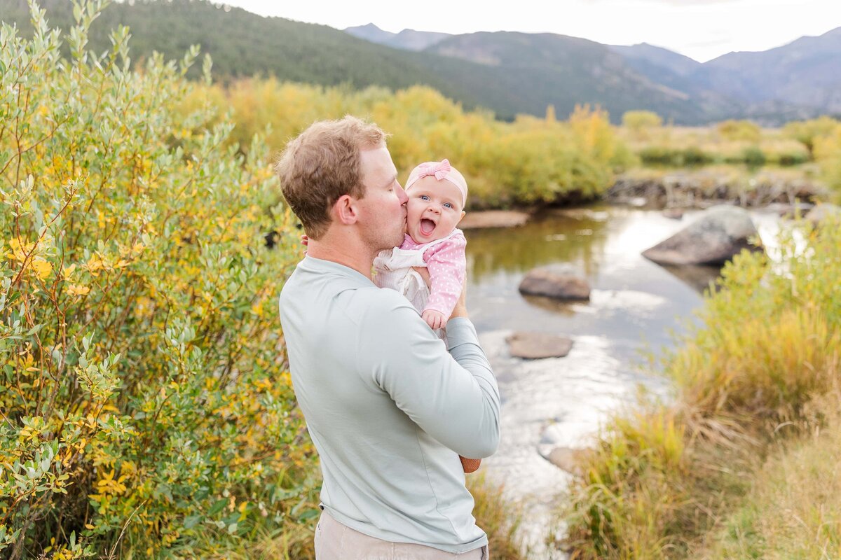 Dad kisses cheek of his baby girl in Moraine Park, CO