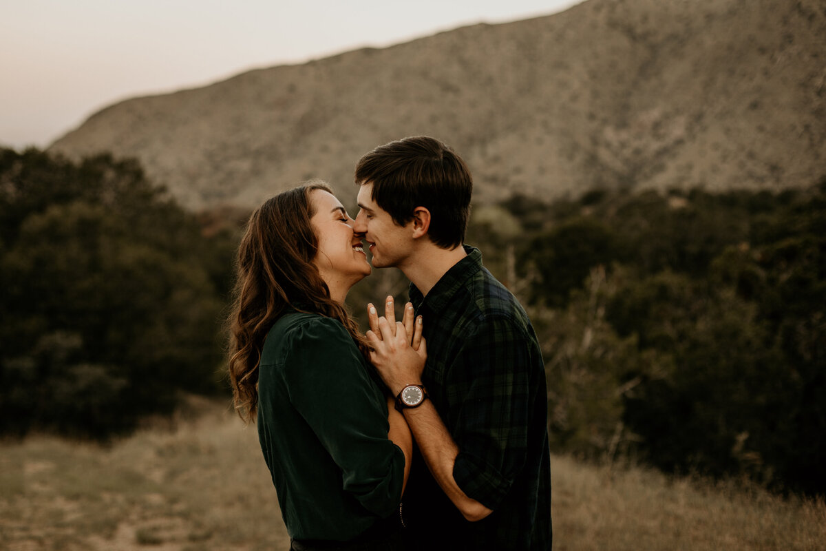 engaged couple holding hands about to kiss