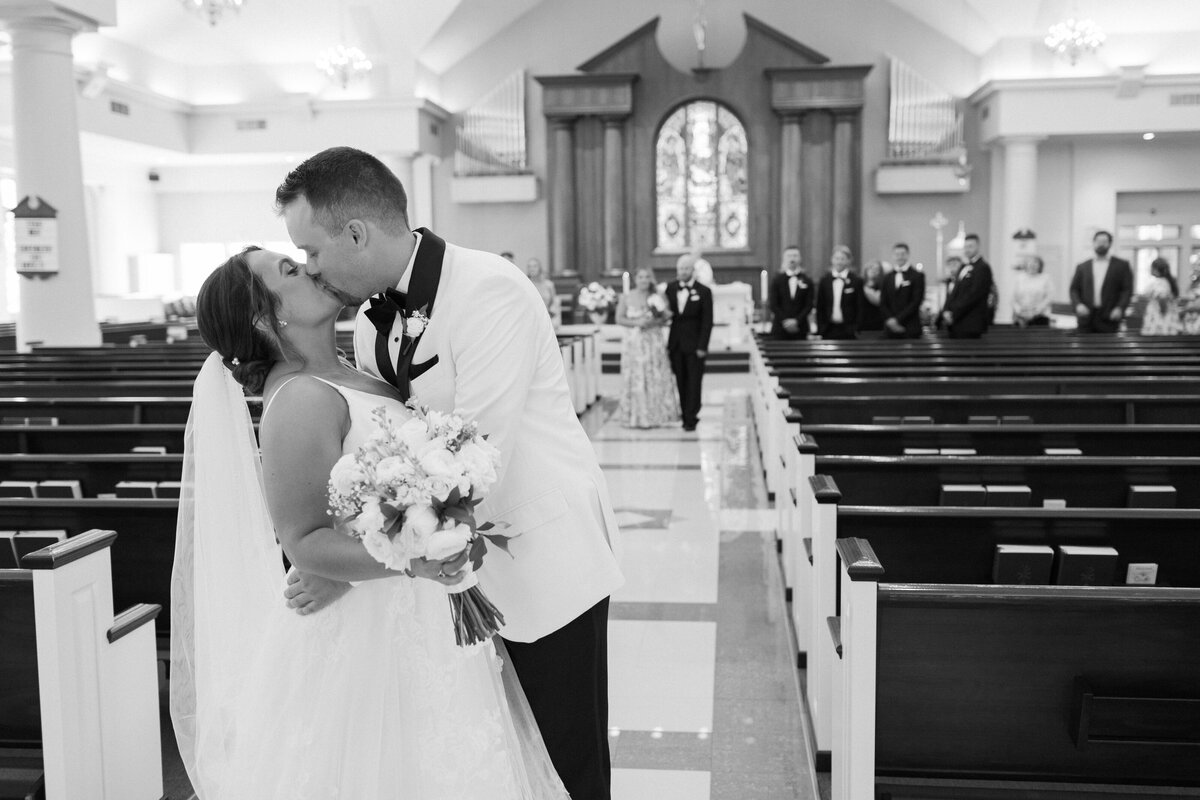 bride-and-groom-kissing-in-aisle