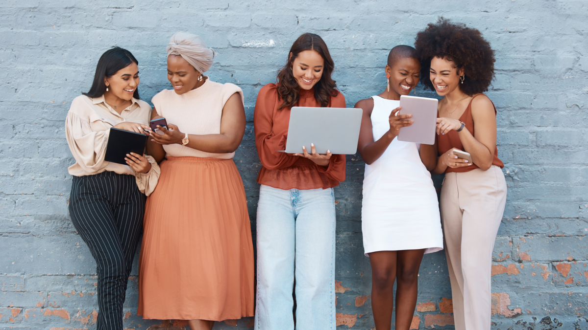 image of women smiling and sharing ideas on devices